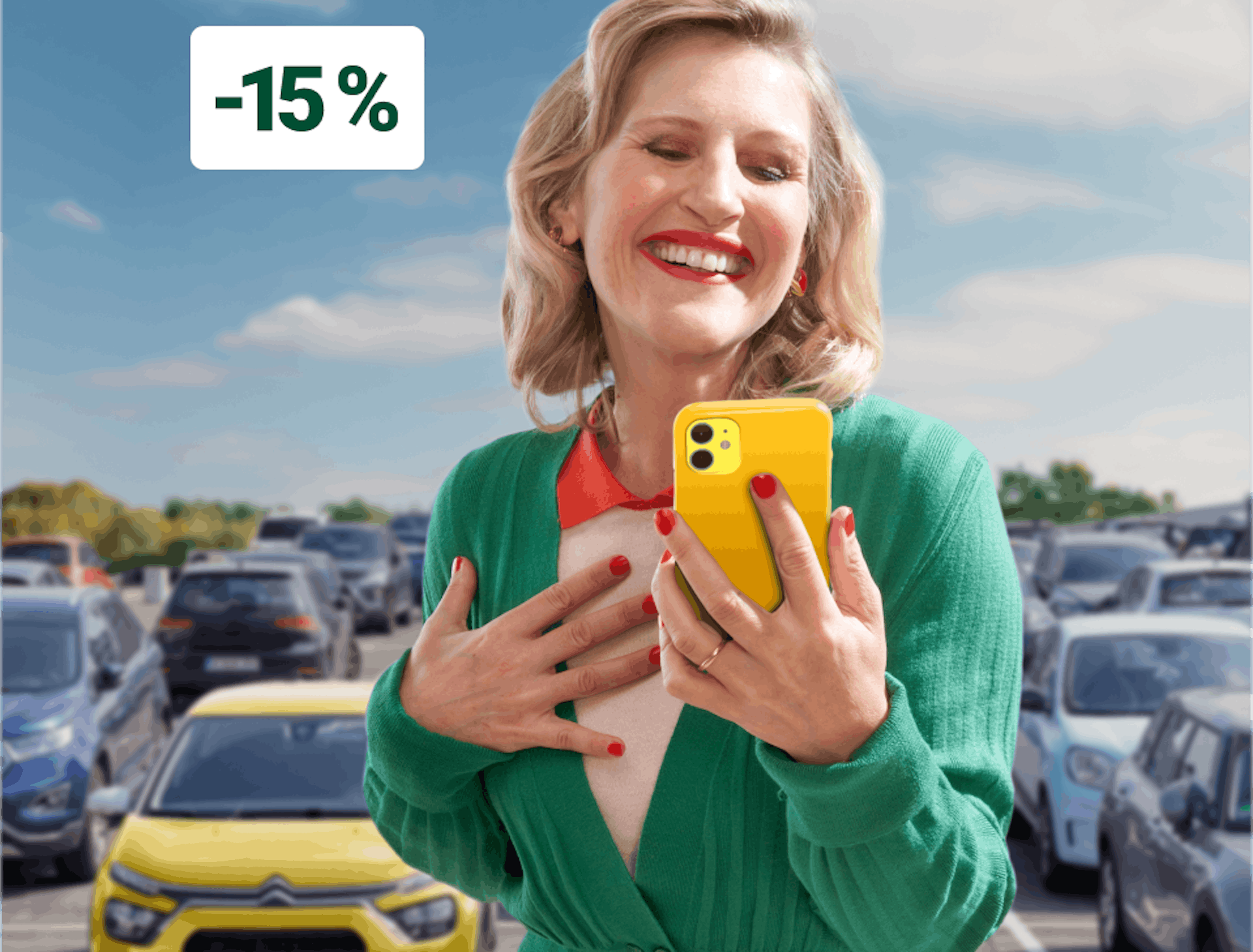 Femme souriante en veste verte tenant un smartphone jaune sur un parking et une étiquette de réduction de -15%